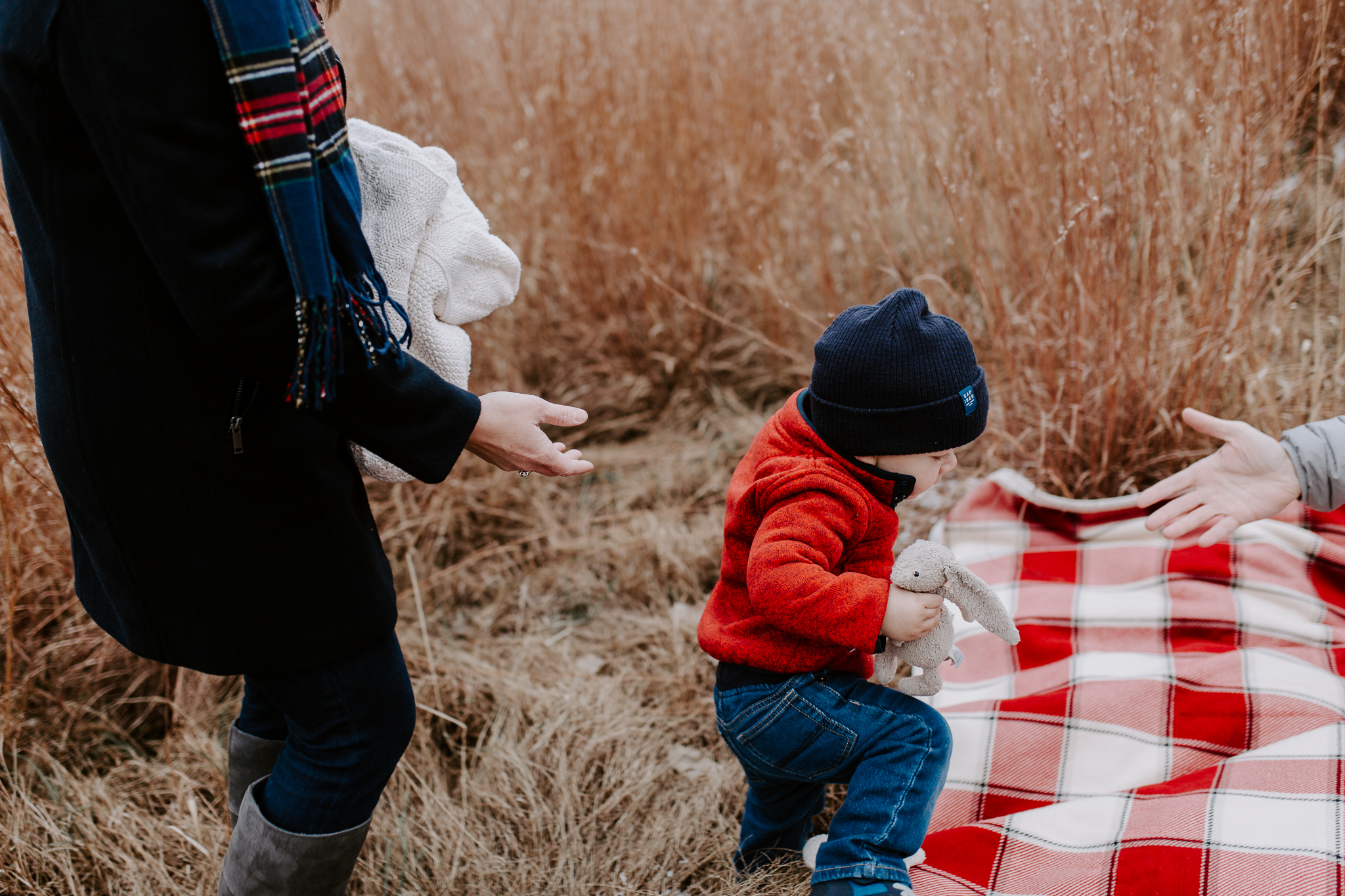 Young family lifestyle photo in a dried grass field with snow.